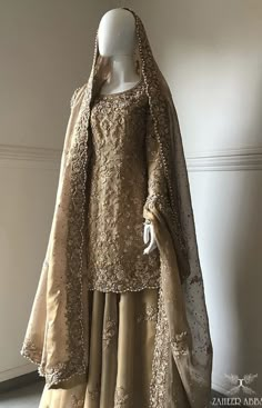 a mannequin dressed in an elegant dress and cape with beading on it