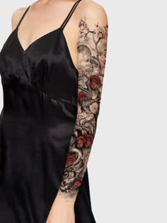 a woman with tattoos on her arm wearing a black dress