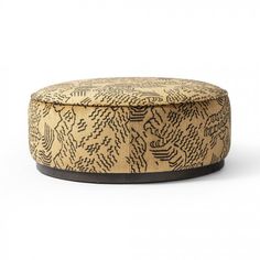 a round wooden box sitting on top of a white surface with black and brown designs