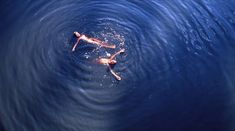 two people floating in the water on their backs