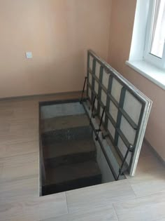 an empty room with stairs leading up to the window