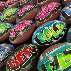 many different colored footballs with the word super bowl written on them are stacked together