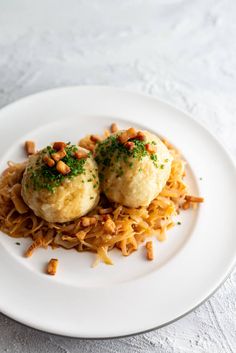 two dumplings on top of noodles with nuts and parmesan sprinkles