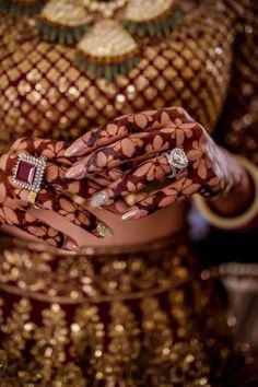 a close up of a woman's hands with bracelets and rings on them