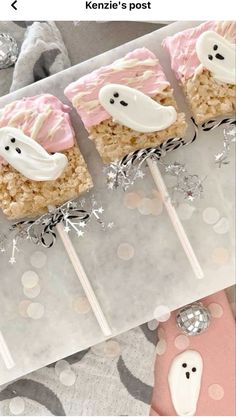 some kind of marshmallow treat with ghost decorations on it and two lollipops in the middle