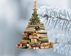 a christmas tree made out of books with a star hanging from it's top