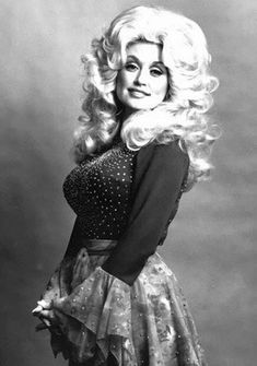 an old photo of a woman with long blonde hair wearing a dress and tights