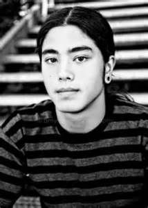 a young man sitting in front of some stairs