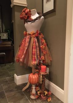 a mannequin is dressed up with fall decorations