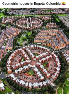 an aerial view of a city with lots of red brick buildings and green grass in the middle