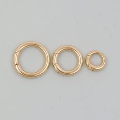 three gold filled jump rings on a white background with space for the word o's