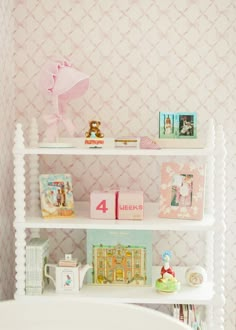 a white shelf filled with lots of different types of toys and books on top of it