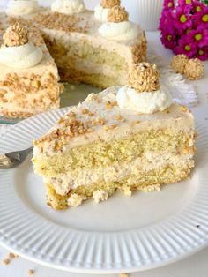 a piece of cake on a plate with a fork next to it and flowers in the background