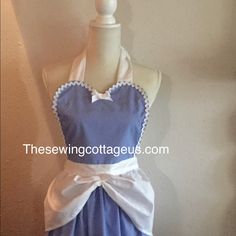 the apron is blue with white trim and has a bow at the waist, along with an attached neckline