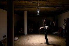 a woman standing in the middle of a dark room