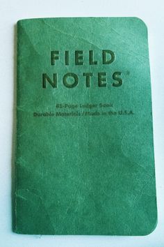 a green field notes sitting on top of a white table