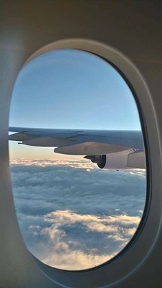 an airplane window looking out at the clouds below