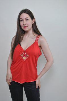 Check out this floral red tank top made of mixed synthetic fabric with flowers embroidery. Good choice for summer festival outfit. Great relaxed top for hippie vibe. Welcome to TARASCOMMON.ETSY.COM Unique clothing from the 20th century. Model tall - 170cm. Size: M. Width - 46cm / 18.11inch; Length - 60cm / 23.62inch. All measurements are taken seam to seam while lying flat. Viscose/ Elastan. This item is vintage, so it can have some defects. Additional photos can be send We are glad that you are Summer Hippie V-neck Top, Orange V-neck Tank Top For Spring, Spring Orange V-neck Tank Top, Red Retro Spring Tank Top, Retro Red Spring Tank Top, Red Cotton Tank Camisole, Retro Red Sleeveless Tank Top, Red Cotton Tank Top For Summer, Orange Vest Top For Spring