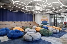 an office with lots of bean bags on the floor and chairs in front of them