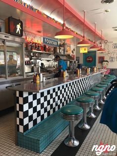 the interior of a diner with checkered counter tops and stools in front of it