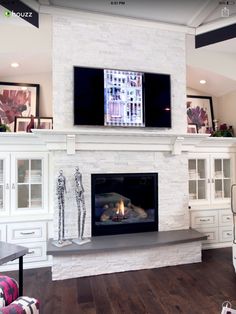 a living room with a fire place and tv on the wall above it's fireplace