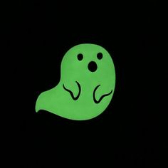 a green ghost in the dark with eyes and nose drawn on it's face