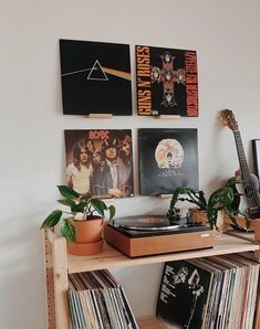 a record player sitting on top of a wooden shelf filled with vinyl records and posters