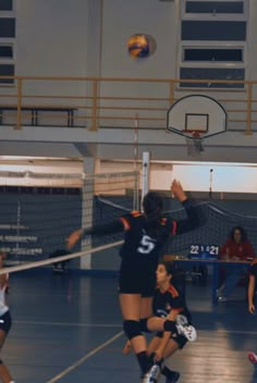 some girls are playing volleyball in a gym