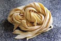 a pile of uncooked pasta sitting on top of a blue carpeted floor