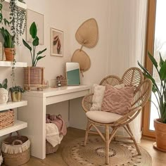 a room filled with lots of plants next to a white desk and chair on top of a hard wood floor