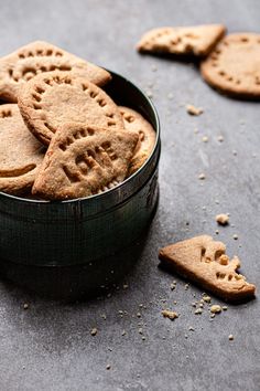 a bowl filled with crackers sitting on top of a gray table next to other cookies