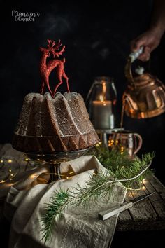 a cake with frosting and a reindeer decoration on top is sitting on a table