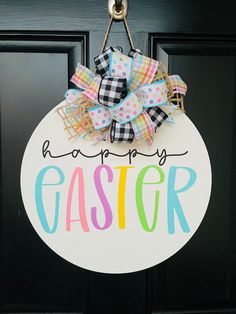 a door hanger that says happy easter with a bow hanging from it's side