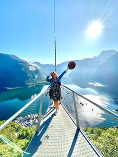 a woman standing on top of a bridge holding a frisbee in her hand