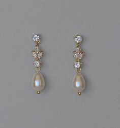 two pairs of earrings with pearls and cubicles on them, all in gold tone