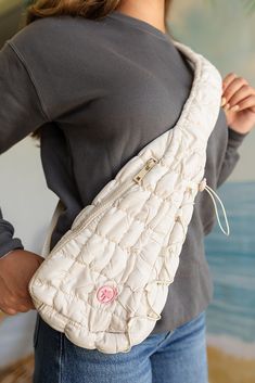 Elevate your accessory game with The Quilted Sling Bag in Ivory. Designed for women, this quilted sling bag combines elegance and functionality, making it the perfect addition to your wardrobe. The soft, quilted texture offers a luxurious feel, while the pink Palmr logo adds a playful touch of sophistication. Imagine carrying this chic ivory crossbody bag, effortlessly complementing your outfit while keeping your essentials organized and within easy reach. Lifestyle Fit The Quilted Sling Bag in Quilted Beige Shoulder Bag For Travel, Beige Quilted Shoulder Bag For Travel, Cream Quilted Shoulder Bag For Everyday Use, Everyday Quilted Cream Shoulder Bag, Cream Quilted Travel Bag, Everyday Cream Quilted Shoulder Bag, White Quilted Shoulder Bag For Travel, White Quilted Shoulder Bag For Everyday Use, Versatile Quilted Beige Bag