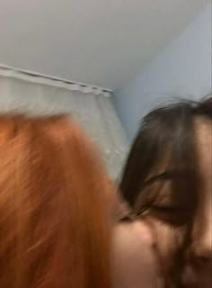 blurry photograph of two women with red hair and one woman has her face close to the camera