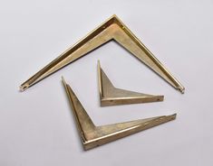 three pieces of brass metal on a white surface