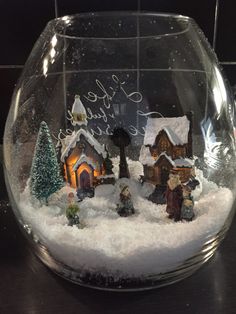 a glass bowl filled with snow and small houses