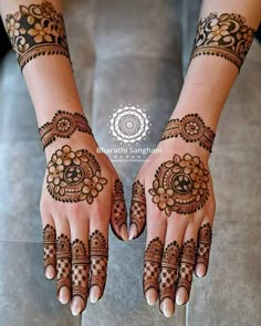 two hands with henna designs on them