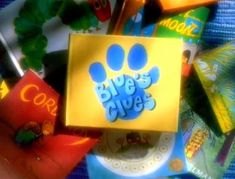 there is a yellow box with blue's clues on it next to other items