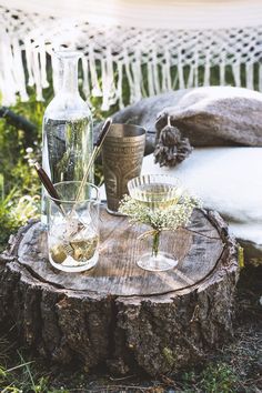 two glasses are sitting on a tree stump