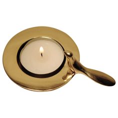 a gold plate with a lit candle in it