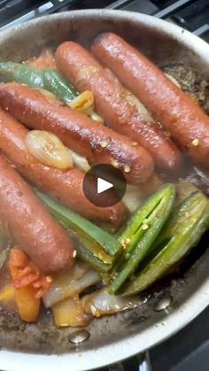 hot dogs and vegetables cooking in a pan on the stove