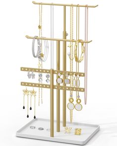 a gold jewelry rack with many different necklaces and earrings hanging from it's sides