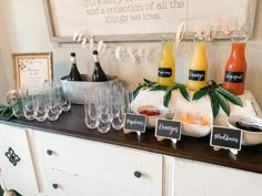 a buffet table with wine glasses, juice and condiments