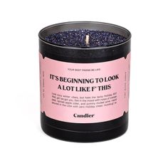 a candle that is in a black container with pink and blue speckles on it