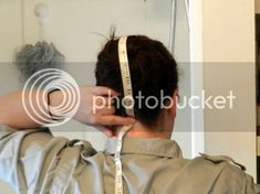 a woman is measuring her hair with a tape around her head and the back of her head