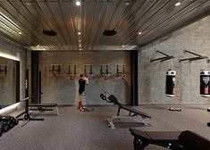 a man standing in front of a gym filled with machines and punching gloves on the wall