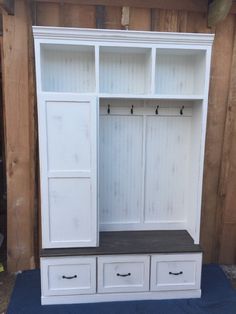 a large white wooden cabinet with drawers